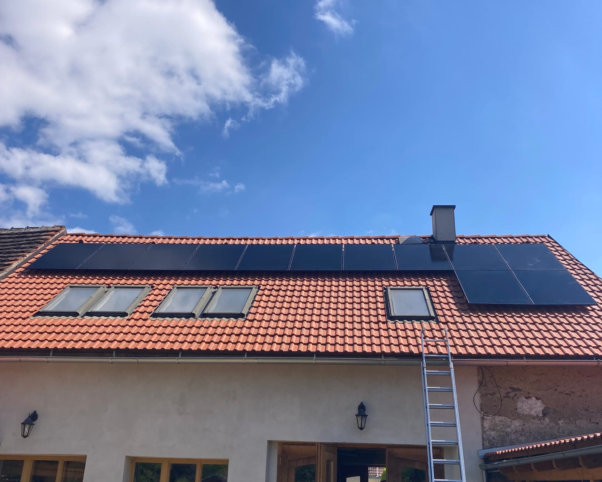 Červená tašková střecha rodinného domu s fotovoltaickými panely mezi střešními okny, Zadní Zborovice