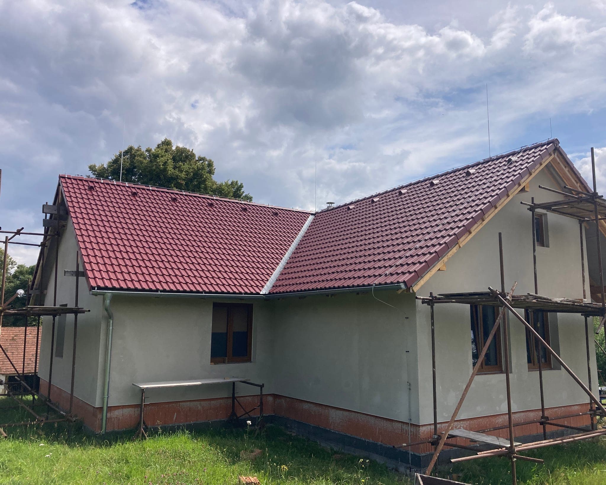 Rodinný dům v lešení během rekonstrukce střechy s nataženým jímacím vedením hromosvodu, Bílsko